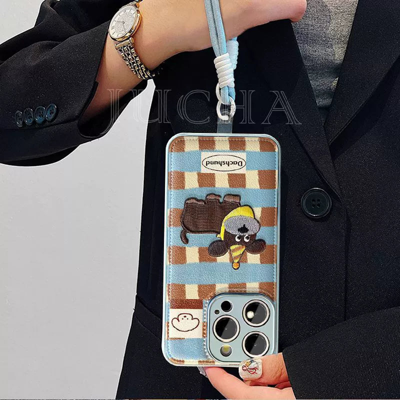 A luxurious smartphone case with a string, featuring a gingham embroidered puppy motif, compatible with iPhone